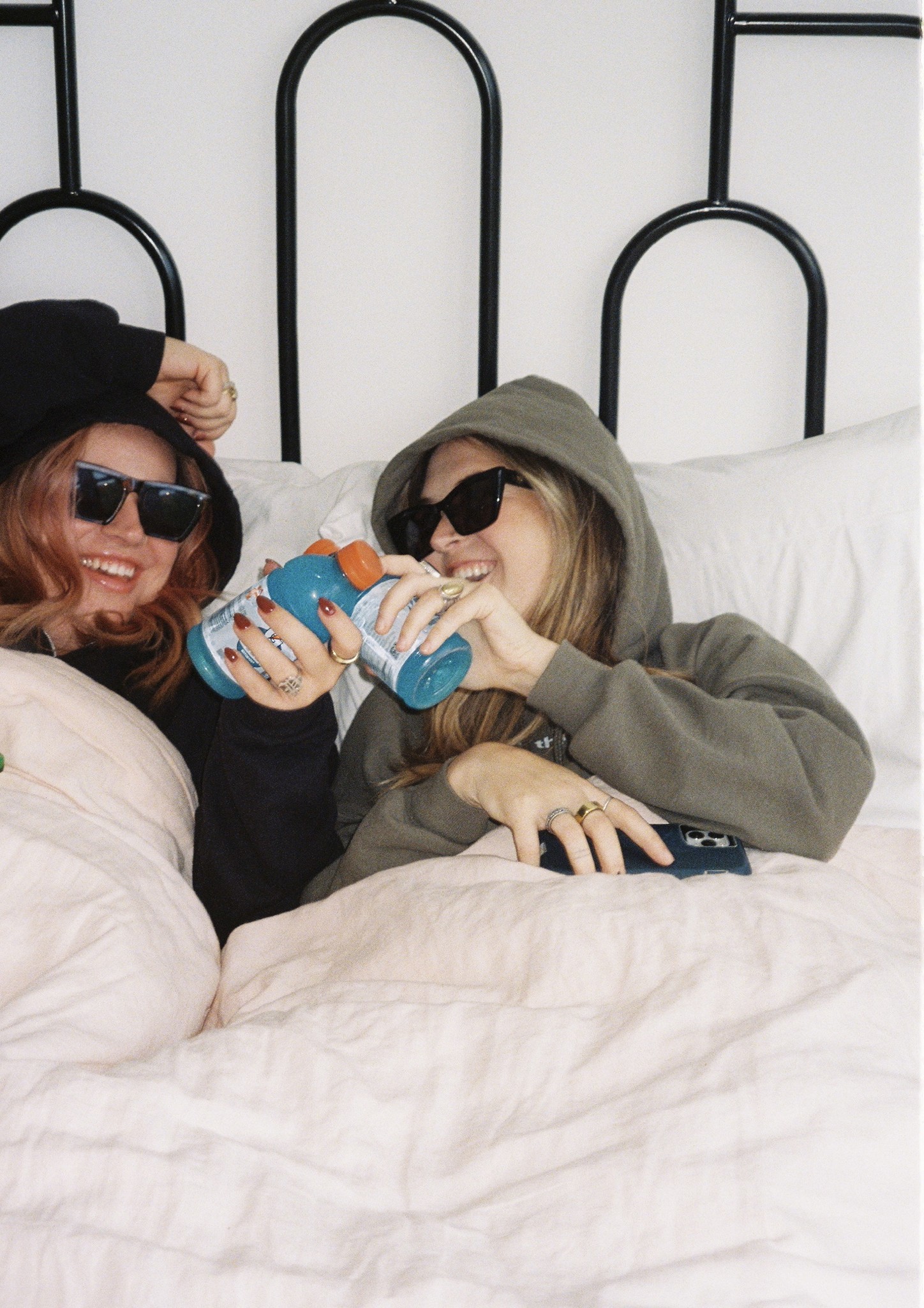 Dos personas riendo en la cama de un piso compartido